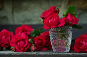 red roses next to and in a short glass vase